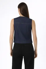 Chaleco de algodón con estampado animal print en tonos grises y negros. Presenta cuello en V, cierre frontal con lazo y botones, y bolsillos delanteros tipo cargo.