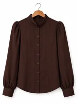 Blusa de color marrón oscuro con textura de rayas verticales finas. Presenta cuello mao, cierre frontal con botones a tono, mangas largas abullonadas con puños ajustados y corte recto.