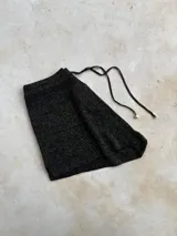 Short de punto con acabado brillante, tiro medio-alto, con cintura elástica y cordones ajustables con punteras metálicas.