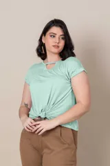 Remera color beige de algodón, con escote redondo con abertura en forma de gota y nudo en el frente.