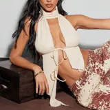 Top color amarillo pastel con cuello halter, espalda descubierta y lazos ajustables en el frente.