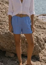 Short de lino color azul marino, de tiro alto, con bolsillos laterales y e incluye un cinto de rafia con hebilla redonda.