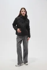 Campera puffer negra con capucha, manga larga y cierre frontal. Presenta un diseño capitoneado con costuras en forma de rombos.