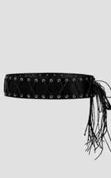 Cinto tipo faja de cuero sintético negro, con diseño de cordones cruzados y ojalillos metálicos plateados. Presenta un extremo con flecos largos decorativos.