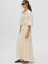 Falda larga confeccionada en broderie de algodón, con diseño de volados escalonados y detalles de galones con transparencias. Presenta una pretina elástica con cordones ajustables para un calce cómodo.