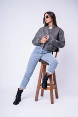 Campera tipo bomber de cuero sintético con efecto desgastado, cuello, puños y ruedo de tejido elástico acanalado, cierre frontal y bolsillos laterales.
