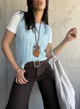 Chaleco celeste de hilo con diseño de trenzas.