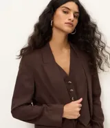 Blazer celeste de viscosa y lino, con cuello inglés, cierre de un botón y solapas.