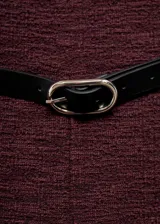 Mono largo de corte recto y diseño sin mangas con cuello barco. Presenta un tejido jaspeado en color bordó, cierre de cremallera en la parte posterior y cinturón fino con hebilla metálica incluido.