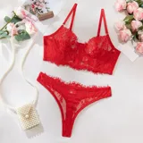 Conjunto de lencería de encaje floral rojo, compuesto por un corpiño tipo bustier con aro y transparencias, y una bombacha colaless en composé.