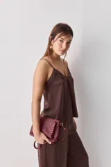 Top negro de breteles finos con escote en V y diseño minimalista, confeccionado en tela fluida y suave.