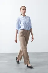 Pantalón de mujer color beige, de corte recto y tiro alto, con costuras frontales marcadas que recorren la pierna.