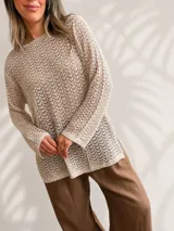 Sweater de tejido calado color beige, con escote redondo, mangas largas y corte amplio y relajado.
