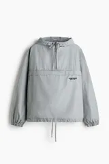 Campera popover de algodón color gris con efecto lavado, cuello elevado, capucha con cordón ajustable, medio cierre y bolsillo frontal con solapa.