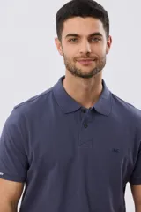 Remera polo de piqué de algodón color azul, de manga corta, con cuello camisero, cierre frontal de dos botones y pequeño logo bordado en el pecho.