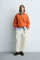 Sudadera regular fit azul marino confeccionada en tejido de algodón con estructura piqué. Cuenta con cuello subido, cierre frontal de cremallera corta y mangas largas con acabados en rib.