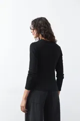 Remera de manga larga color blanco, de calce entallado, con cuello redondo a la base y costuras verticales decorativas que estilizan la silueta.