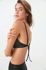 Soutien sin aro de tricot calandrado color negro, con breteles regulables en la espalda.