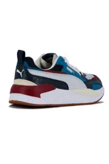 Championes deportivos Puma X-Ray en combinación de azul, gris y negro, con detalles en amarillo flúor y suela blanca y azul.
