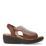 Sandalias de cuero negro con plataforma baja, diseño de puntera abierta y detalle de perforaciones decorativas en la capellada. Cuenta con ajuste mediante velcro en la parte posterior.