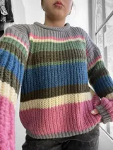 Sweater de punto grueso a rayas horizontales de colores gris, rosa, verde, azul, marrón y crema, con cuello redondo y mangas largas.