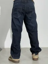 Jean de corte baggy con diseño de costuras laterales curvas, color azul oscuro con efecto lavado.