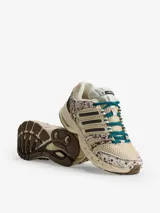 Championes Adidas Adistar Control 5 W, con diseño de running inspirado en los años 2000. Combinan tonos beige, marrones y detalles estampados tipo animal print con efecto de pelo, cordones verde oscuro y las icónicas tres tiras de la marca en los laterales.