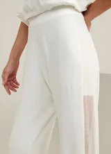 Pantalón jogger blanco de malla, con cintura elastizada, bolsillos traseros y detalle de rayas de malla en los laterales.