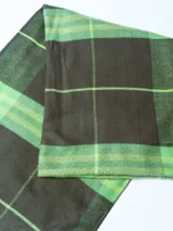 Bufanda tipo pashmina color marrón con diseño a cuadros en azul, blanco y gris.