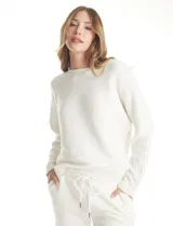 Buzo de punto con textura acanalada horizontal, de calce holgado y diseño con mangas japonesas. Presenta escote a la base y acabado liso.