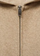 Chaqueta tipo bomber con capucha, confeccionada en tejido de poliéster con textura suave. Presenta cierre frontal de cremallera, mangas largas con puños elásticos y cintura acanalada.