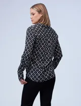 Camisa Alex & Jordan de manga larga, color negro con estampado geométrico blanco. Presenta cuello con solapa, escote en V y cierre frontal con botones.