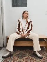 Campera con capucha, de tela tipo peluche a rayas verticales color marrón y blanco, con ribete color beige.