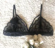 Bralette negro de encaje con tiras finas ajustables y escote triangular.