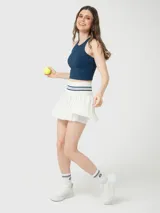 Top deportivo de sujeción media en color azul denim, con cuello alto y diseño de espalda cruzada. Presenta un corte crop y ajuste ceñido al cuerpo.