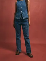 Jean azul de tiro alto, corte recto y aberturas en los tobillos.