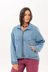 Campera de jean color celeste con silueta relajada y calce amplio. Presenta cierre frontal metálico, cuello clásico y bolsillos laterales.
