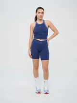 Top deportivo Umbro modelo Kia, color azul marino con detalles en gris en el cuello y sisas. Cuenta con logo estampado en el pecho y diseño de espalda deportiva.