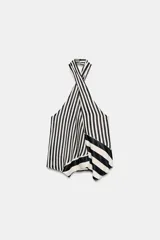 Top de cuello halter cruzado con estampado de rayas verticales y diseño asimétrico en el bajo. Espalda descubierta con cierre trasero de botón.