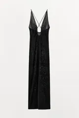 Vestido largo de punto negro con hilatura de viscosa, escote en pico pronunciado con abertura central, tirantes finos cruzados en la espalda y diseño fluido.