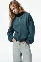 Chaqueta de punto pesado con escote redondo, cierre frontal y bolsillos laterales insertados. Diseño oversized con hombros caídos, puños y bajo elásticos.