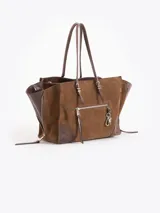 Cartera tote de cuero vacuno color blanco, de diseño estructurado con fuelles laterales expandibles mediante cierres y bolsillos externos con cierre y tiradores metálicos personalizados.