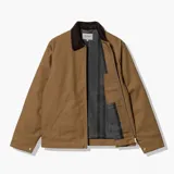Chaqueta Carhartt modelo Detroit, color tostado, con cuello de pana en contraste, cierre frontal con cremallera, bolsillo en el pecho con cremallera y logo de la marca bordado.