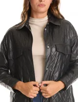 Chaqueta de eco cuero negro con diseño capitoneado, cuello con solapa y cierre frontal con botones a presión. Presenta mangas largas con puños abotonados, dos bolsillos frontales con solapa y forro interno a tono.