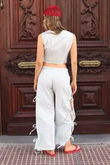 Pantalón negro de tejido ligero, corte holgado, cintura elastizada y aberturas laterales con lazos.