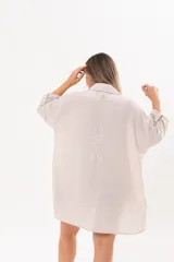 Vestido camisero beige de lino, con escote en V, cuello clásico, mangas tres cuartos regulables y cierre frontal de botones.