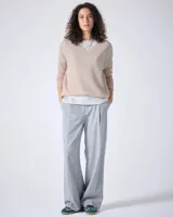 Sweater de punto fino color gris claro, con cuello en V y mangas largas. El tejido parece ser ligeramente transparente o muy liviano.