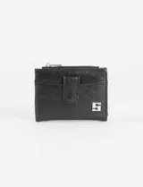 Billetera tipo flap de acabado brillante, con cierre frontal a presión y compartimento con cierre superior. Presenta un aplique metálico decorativo en la parte inferior.