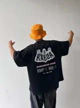 Remera oversize gris con efecto acid wash y estampa frontal con la leyenda "WORLDWIDE TOUR" en tipografía gótica.