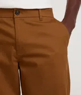 Pantalón de corte recto para hombre, color marrón, confeccionado en sarga. Cuenta con cintura con trabillas, cierre frontal tradicional y bolsillos laterales y traseros.